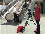 Mat and Skylar record video on escalator in mail hall at conference 